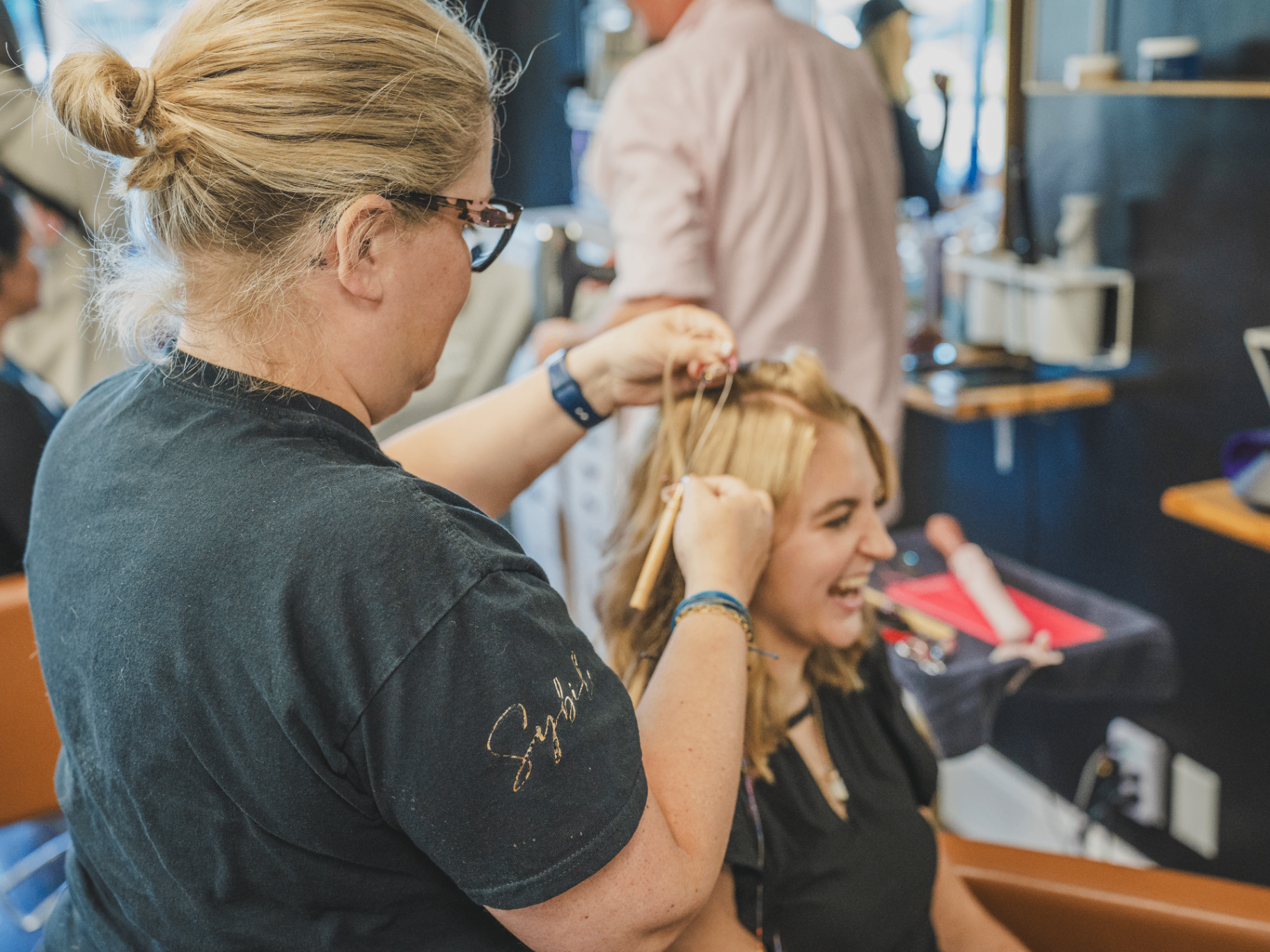 Stylist curling a guest's hair during the Haute Mile event